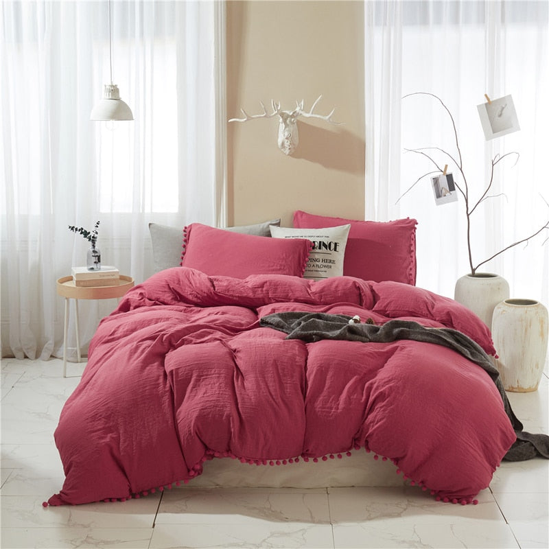 Einfarbiger Bettbezug mit roten Pompons